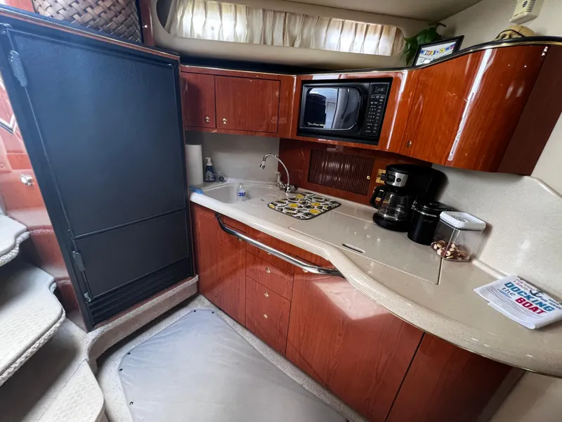 Slide: The Image of Interior of 2000 Sea Ray 380 Sundancer yacht kitchen with wood cabinets and appliances. - 23