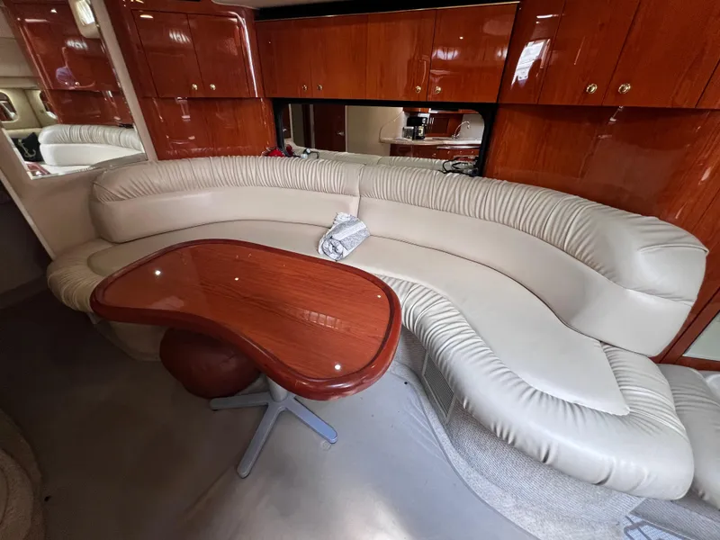 Slide: The Image of Luxurious interior of 2000 Sea Ray 380 Sundancer with curved leather seating and wooden table. - 25
