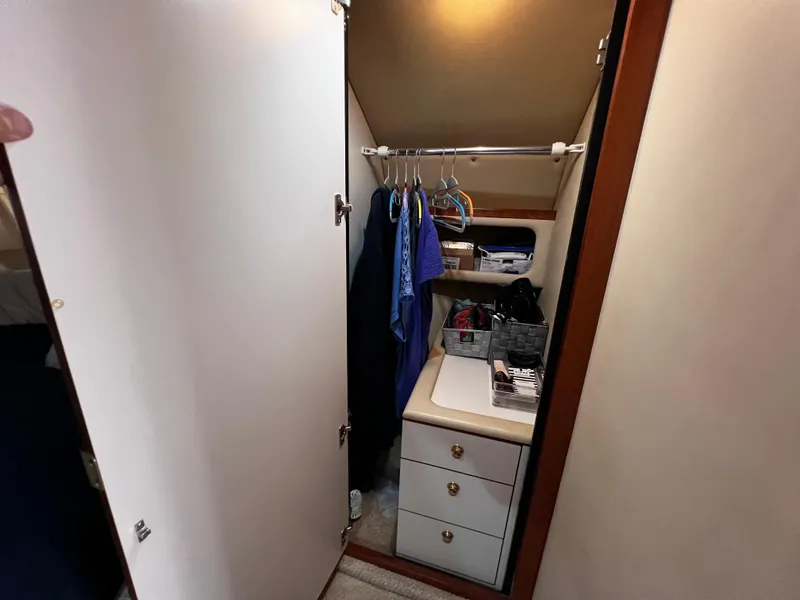 Slide: The Image of Interior closet of 2000 Sea Ray 380 Sundancer with clothes and storage shelves. - 31