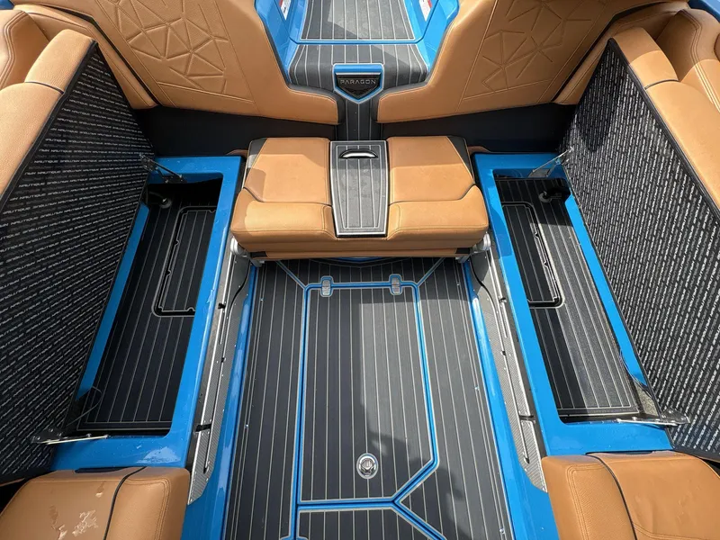 Slide: The Image of 2021 Nautique Super Air Nautique G23 Paragon interior with tan seats and blue accents. - 15