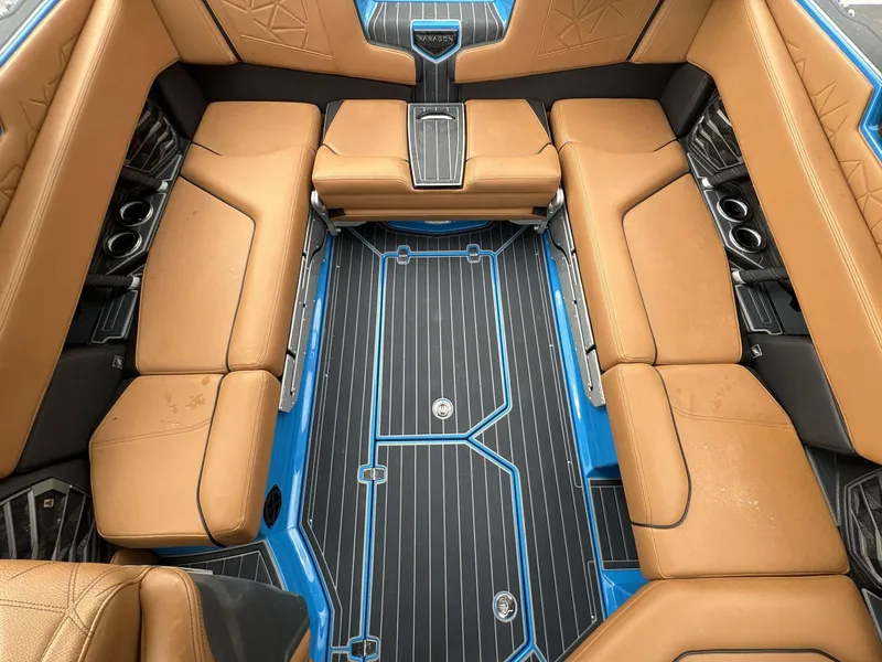 Slide: The Image of 2021 Nautique Super Air Nautique G23 Paragon interior with tan seating and blue accents. - 20