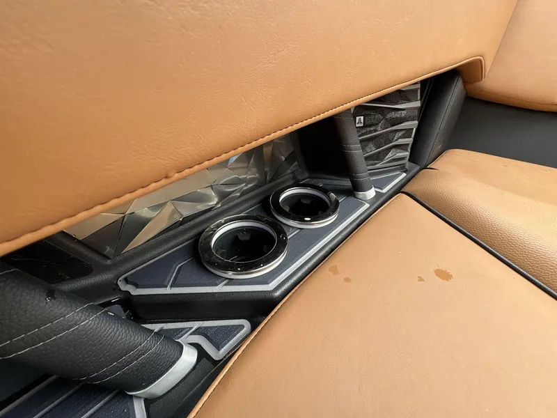 Slide: The Image of 2021 Nautique Super Air Nautique G23 Paragon interior with tan leather seats and cup holders. - 21