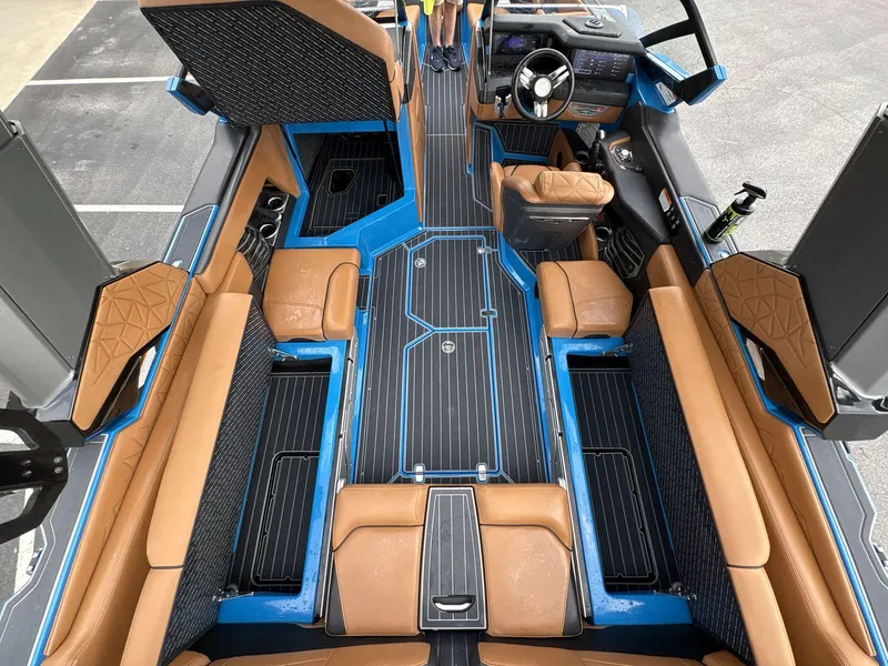 Slide: The Image of 2021 Nautique Super Air Nautique G23 Paragon interior with tan seats and blue accents. - 24