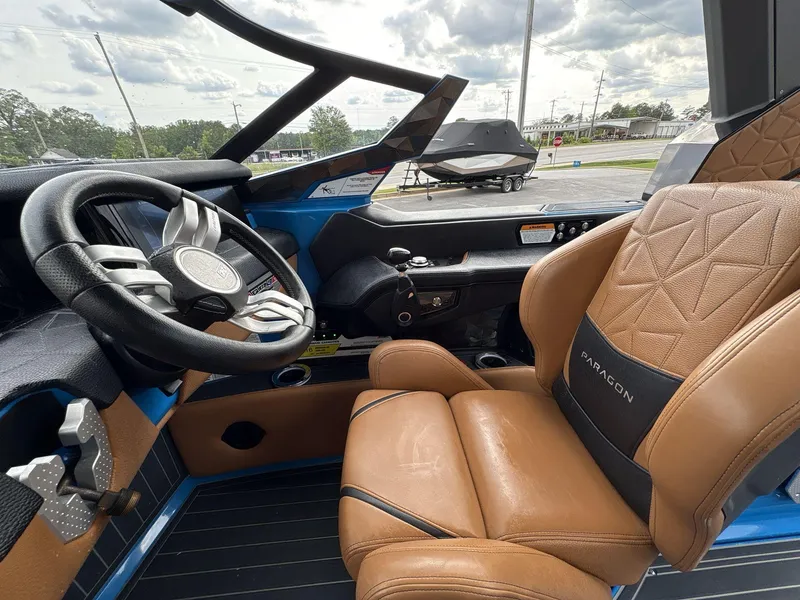 Slide: The Image of 2021 Nautique Super Air Nautique G23 Paragon cockpit with luxury leather seating and modern steering wheel. - 25