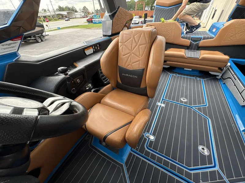 Slide: The Image of 2021 Nautique Super Air Nautique G23 Paragon interior with tan leather seats and blue accents. - 28