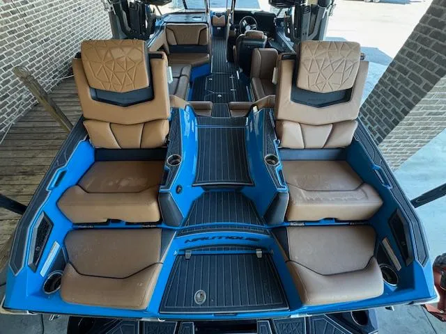 Slide: The Image of 2021 Nautique Super Air Nautique G23 Paragon interior with tan seats and blue accents. - 35