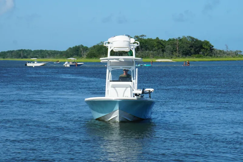 Slide: The Image of 2020 Canyon Bay 24H boat cruising on a scenic lake with distant trees. - 20