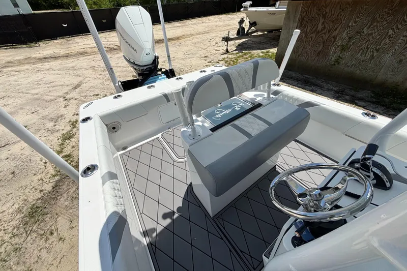 Slide: The Image of 2020 Canyon Bay 24H boat interior with steering wheel and seating, parked on sandy ground. - 29