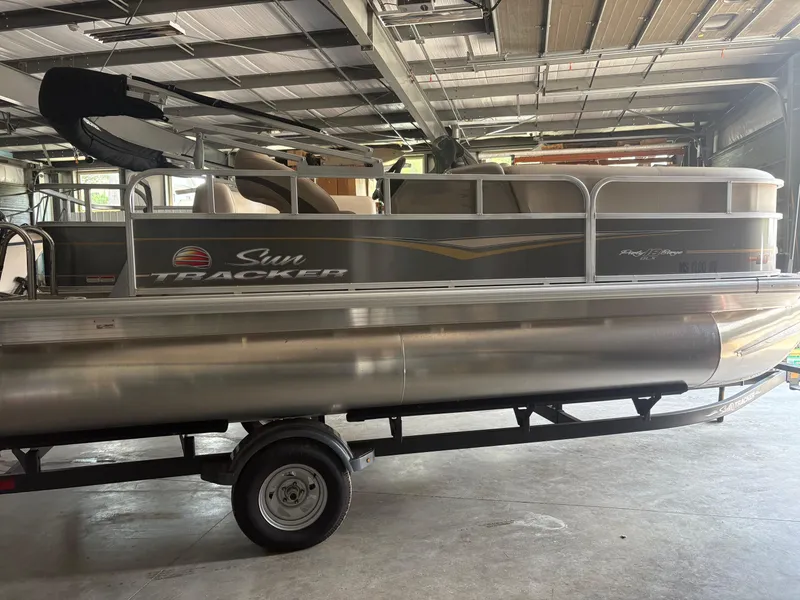 Slide: The Image of 2023 Sun Tracker PB 18 DLX pontoon boat in a garage setting. - 3