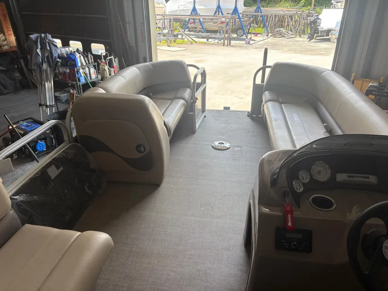 Slide: The Image of Interior of a 2023 Sun Tracker PB 18 DLX pontoon boat in a garage setting. - 6