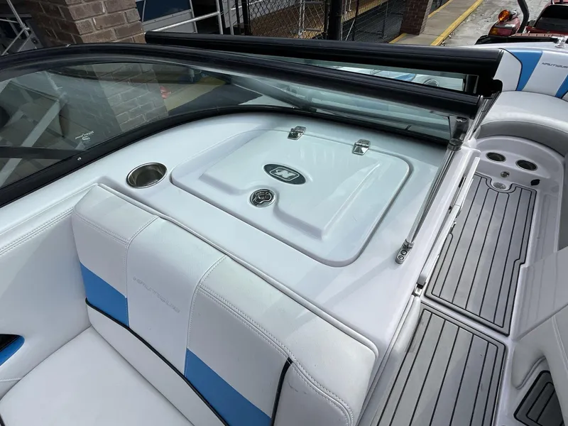 Slide: The Image of 2011 Nautique Super Air Nautique 230 interior with white and blue seating and deck. - 22