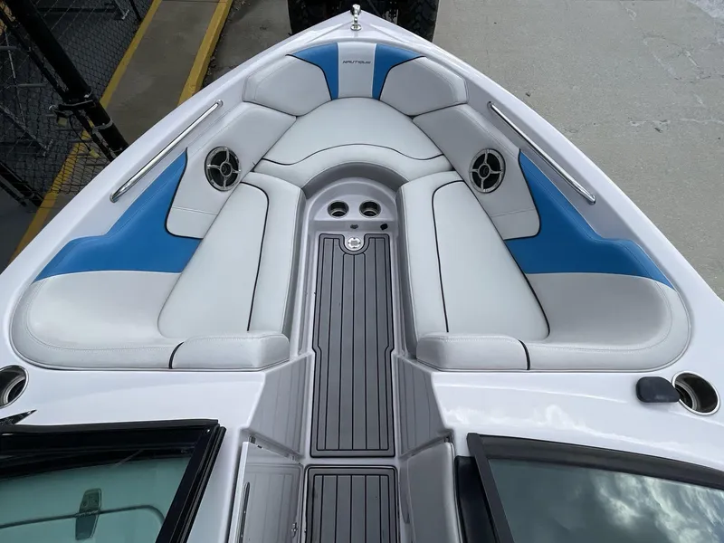 Slide: The Image of 2011 Nautique Super Air Nautique 230 boat interior with blue and white seating. - 30