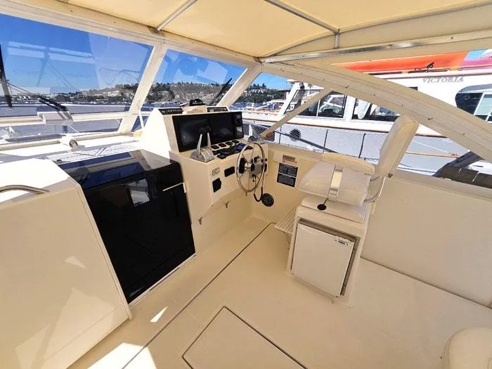 Slide: The Image of 2001 Carolina Classic Express 35 boat cockpit with steering wheel and navigation equipment. - 10