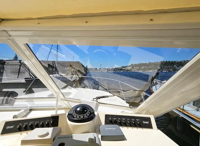 Slide: The Image of 2001 Carolina Classic Express 35 helm view, featuring navigation instruments and scenic waterfront. - 12