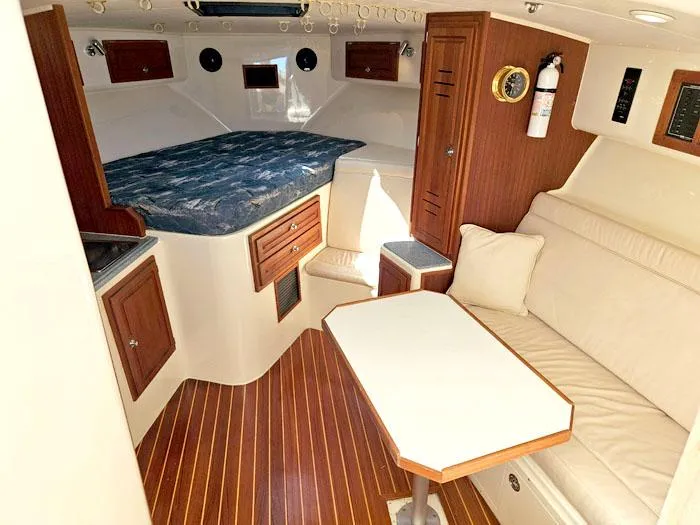 Slide: The Image of Interior of 2001 Carolina Classic Express 35 boat with wood accents and cozy seating area. - 18