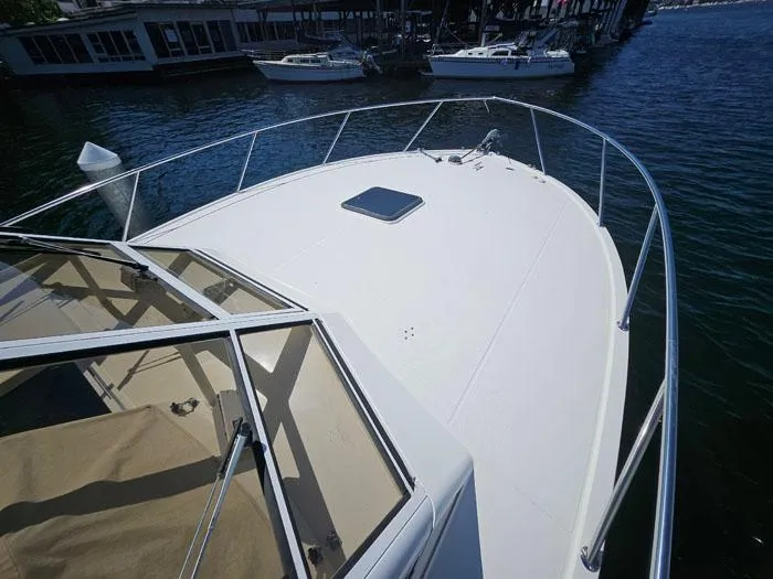 Slide: The Image of 2001 Carolina Classic Express 35 boat deck, docked near other vessels. - 2