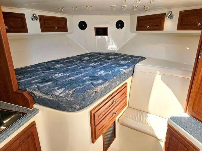 Slide: The Image of Interior cabin of a 2001 Carolina Classic Express 35 with bed and wooden cabinets. - 21