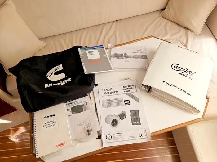Slide: The Image of Owner's manuals and documents for a 2001 Carolina Classic Express 35 boat on a table. - 29