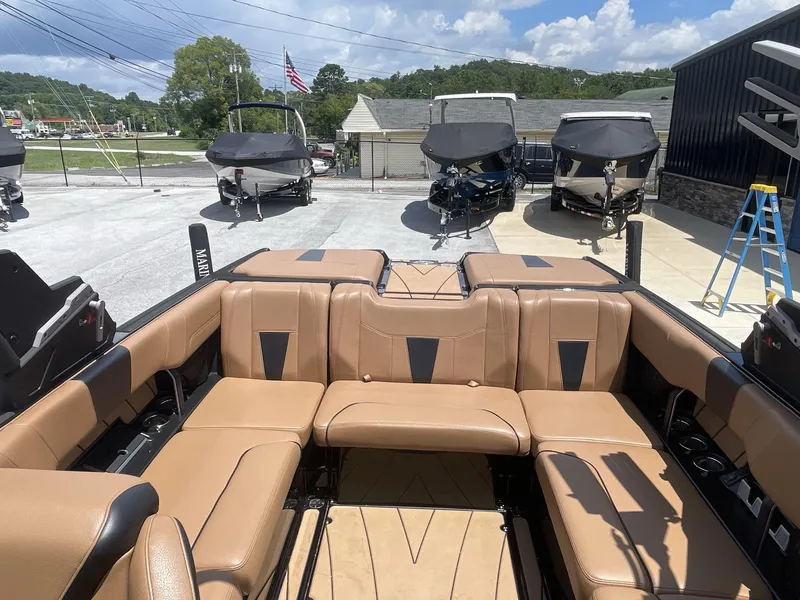 Slide: The Image of 2022 Malibu Wakesetter 23 LSV interior with tan leather seating, parked among other boats. - 16