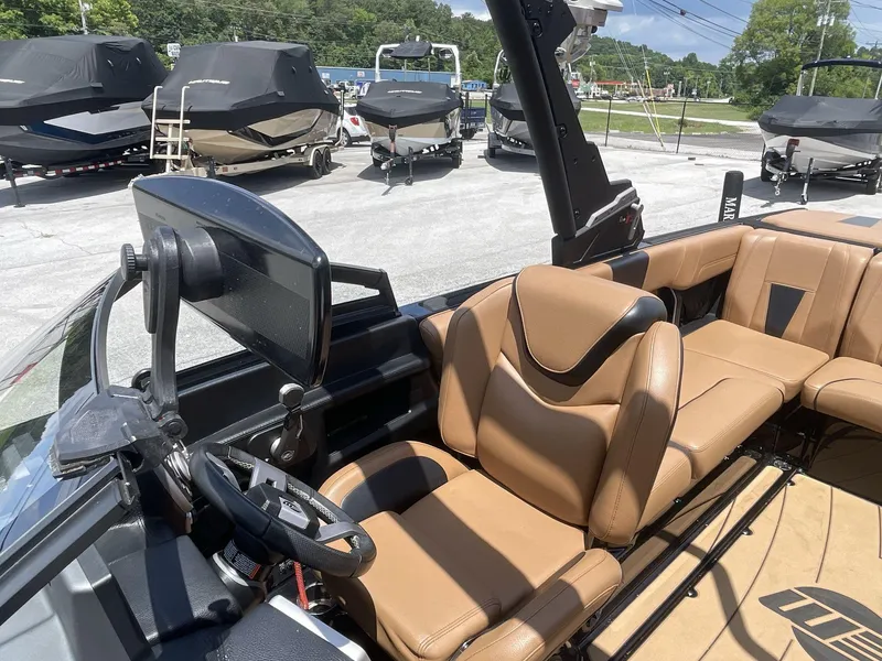 Slide: The Image of 2022 Malibu Wakesetter 23 LSV interior with tan leather seats and steering console. - 26