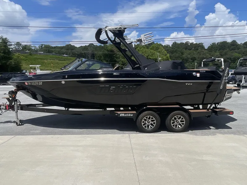 Slide: The Image of 2022 Malibu Wakesetter 23 LSV boat on trailer, black exterior, parked outdoors. - 4