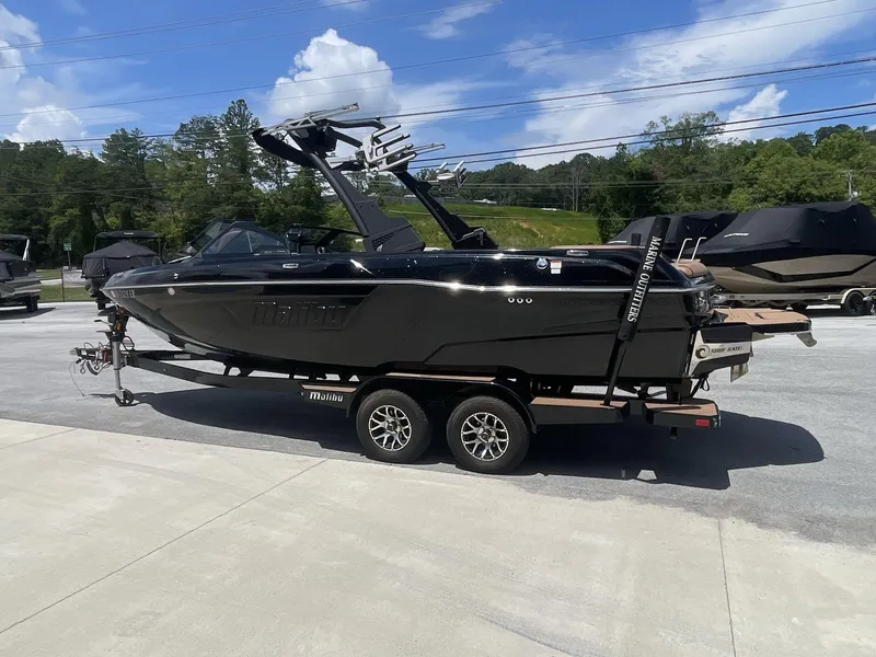 Slide: The Image of 2022 Malibu Wakesetter 23 LSV boat on trailer, parked outdoors under blue sky. - 5