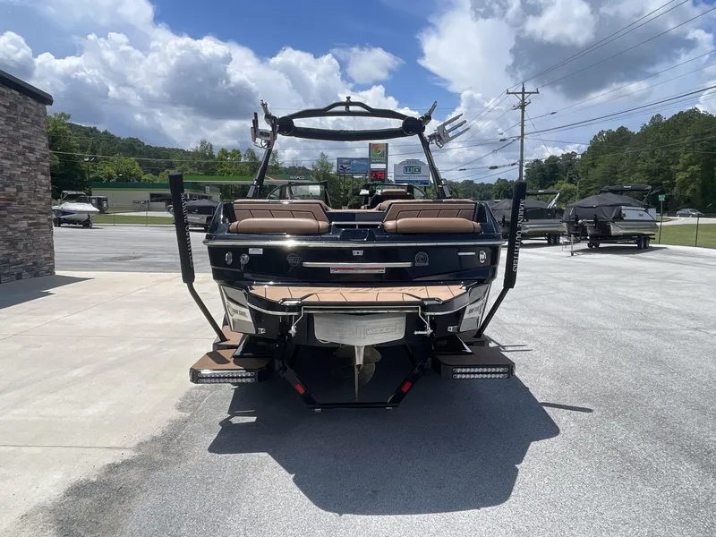 Slide: The Image of 2022 Malibu Wakesetter 23 LSV boat, rear view, parked outdoors under a cloudy sky. - 6