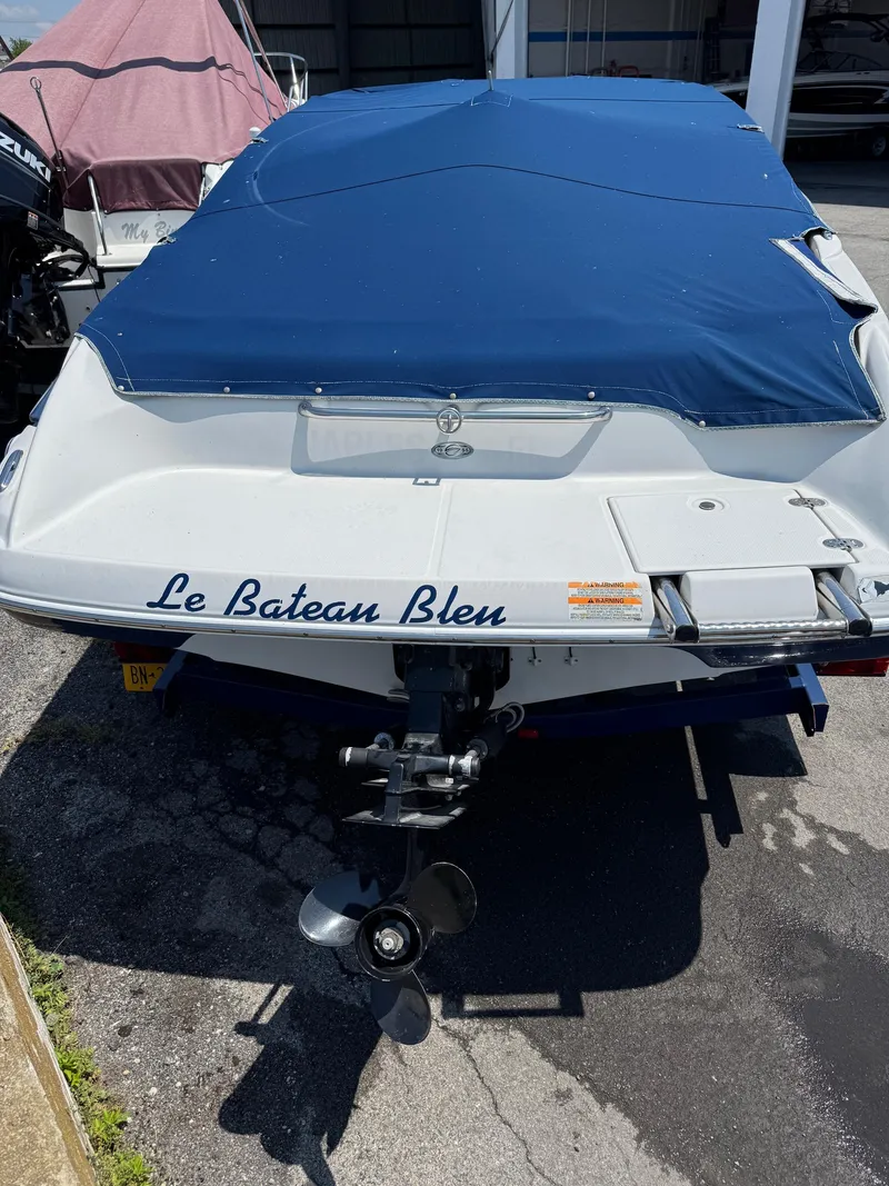 Slide: The Image of 2007 Crownline 19SS boat with blue cover, named "Le Bateau Bleu," parked on pavement. - 4