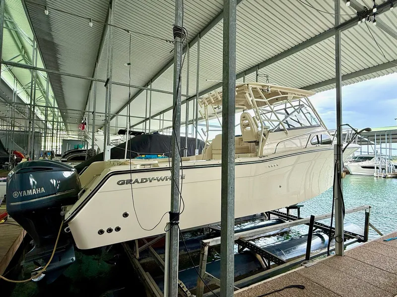 Slide: The Image of 2018 Grady-White Marlin 300 boat docked with Yamaha engines in a covered marina. - 16