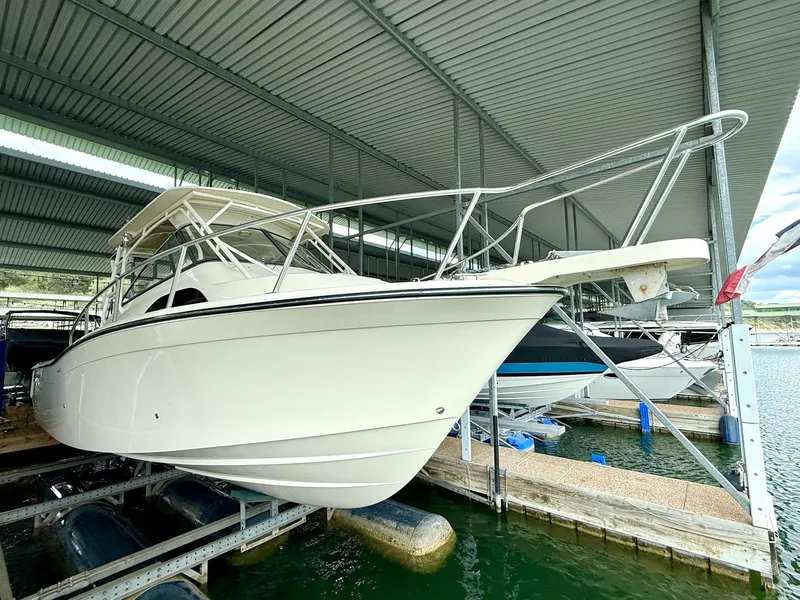 Slide: The Image of 2018 Grady-White Marlin 300 boat docked under a covered marina. - 18