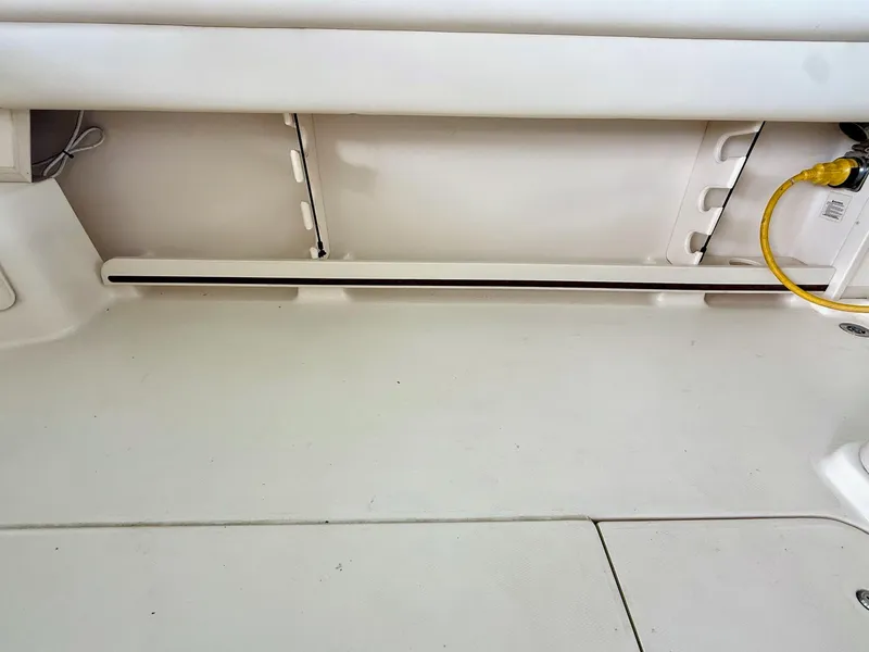 Slide: The Image of 2018 Grady-White Marlin 300 boat interior with storage compartment and yellow cable. - 23