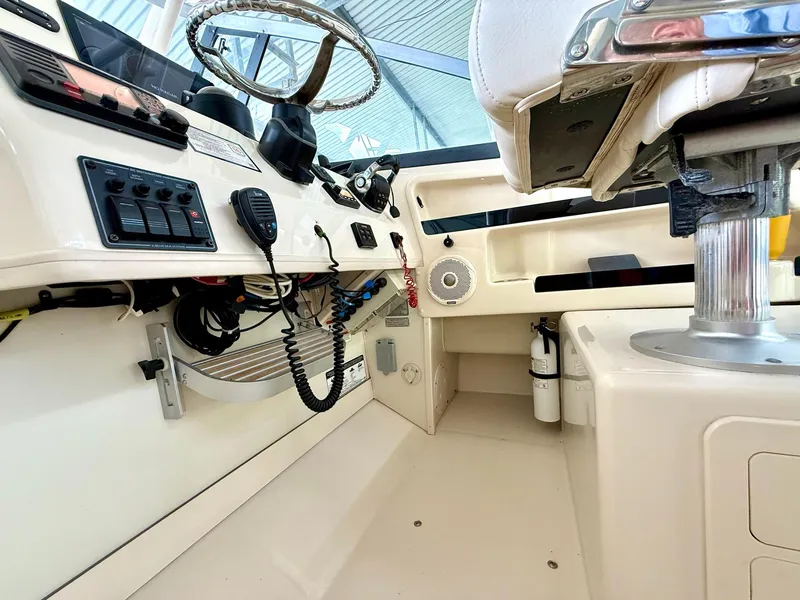 Slide: The Image of 2018 Grady-White Marlin 300 boat cockpit with steering wheel and control panel. - 32