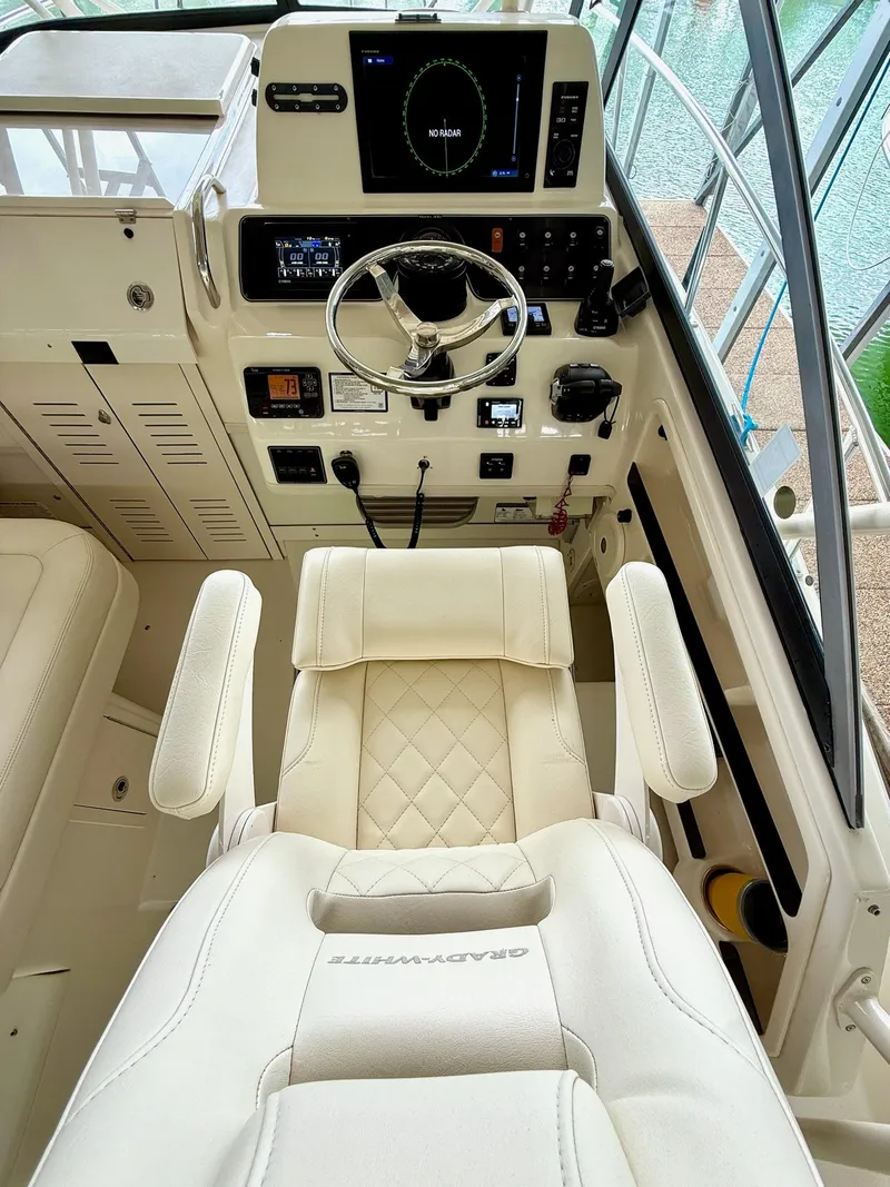 Slide: The Image of Captain's chair and helm of 2018 Grady-White Marlin 300 boat, featuring modern controls. - 33