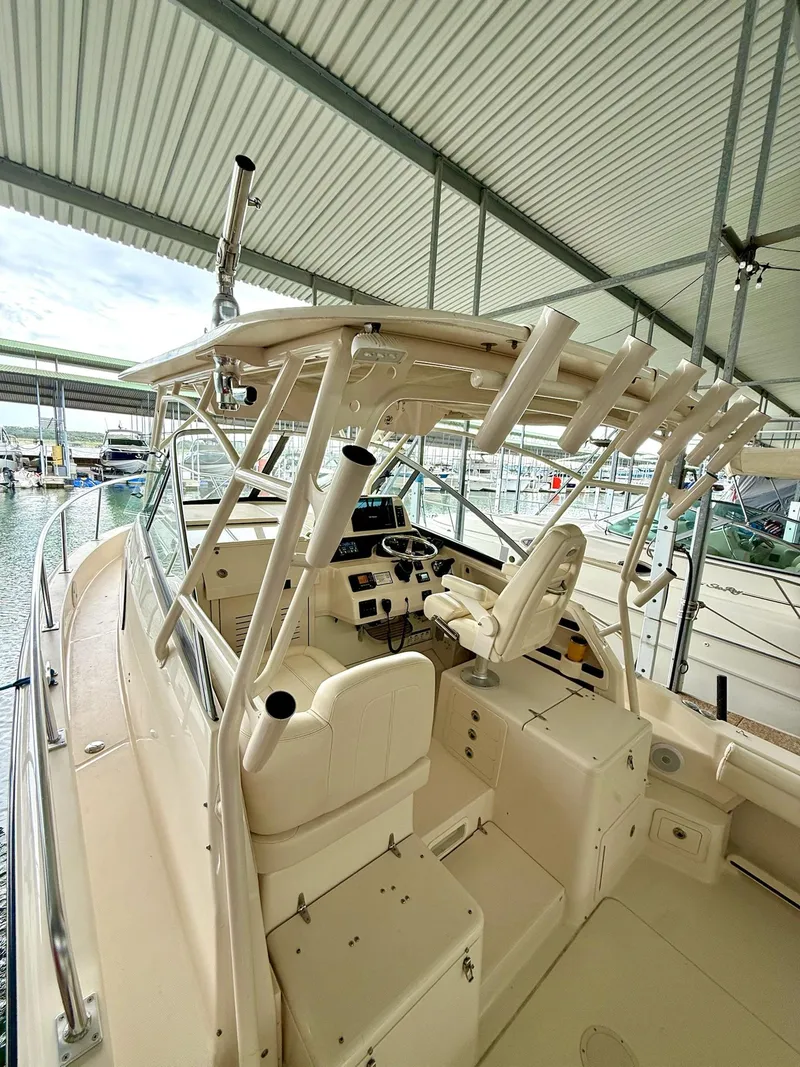 Slide: The Image of 2018 Grady-White Marlin 300 boat interior with helm and seating under a covered dock. - 40