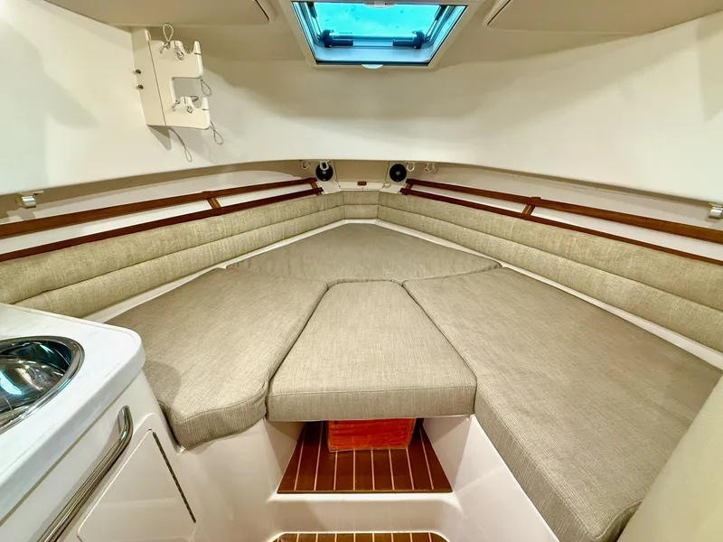 Slide: The Image of 2018 Grady-White Marlin 300 cabin interior with cushioned seating and skylight. - 48