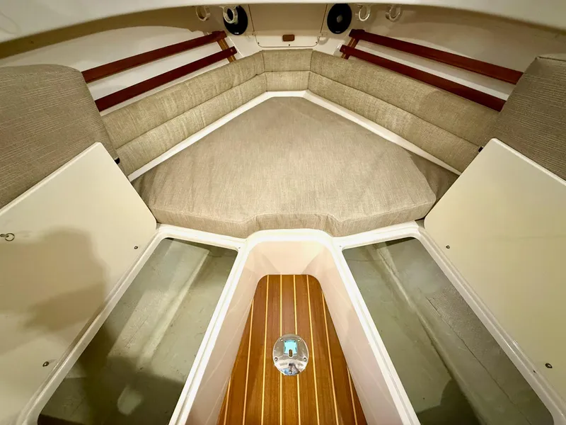 Slide: The Image of 2018 Grady-White Marlin 300 cabin interior with cushioned seating and storage compartments. - 49