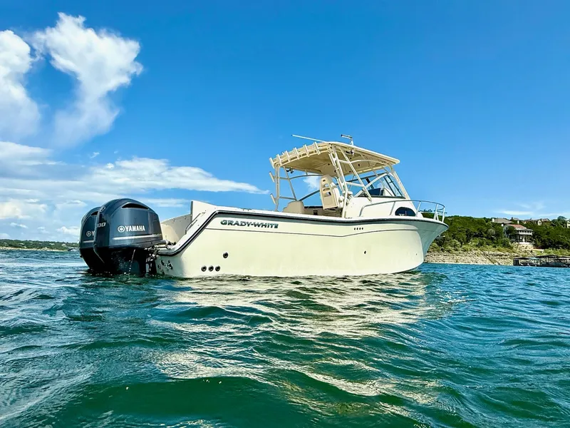Slide: The Image of 2018 Grady-White Marlin 300 boat on water, clear blue sky background. - 7