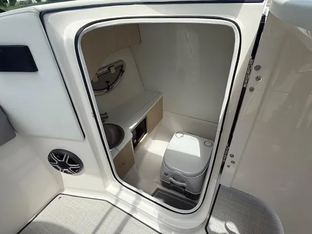 Slide: The Image of 2026 Regal LS6 boat interior with compact bathroom, featuring a toilet and sink. - 13
