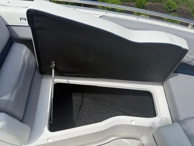 Slide: The Image of Open storage compartment on 2026 Regal LS6 boat, featuring cushioned seating. - 20