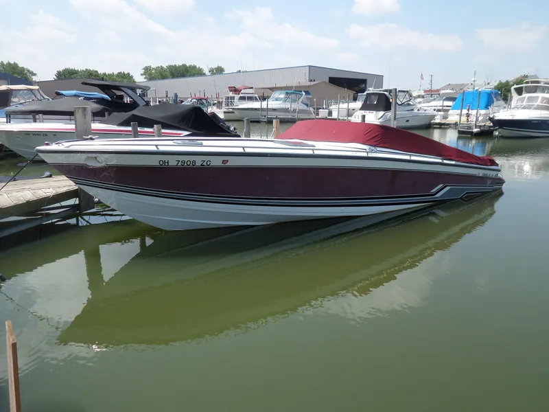 The Image of 1989 Formula F272 SR 1 boat docked in a marina, covered with a red tarp. - 1