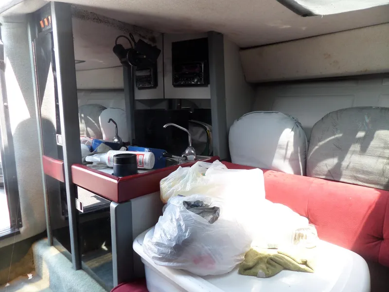 Slide: The Image of Interior of 1989 Formula F272 SR 1 boat with red seating and cluttered table. - 18