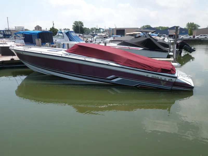 Slide: The Image of 1989 Formula F272 SR 1 boat docked with red cover, marina background. - 2