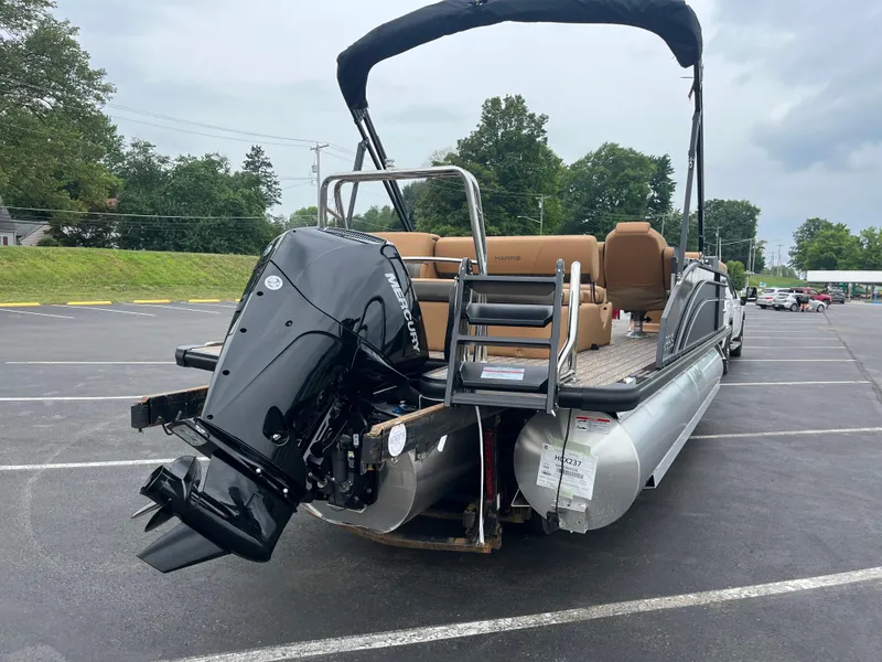 Slide: The Image of 2026 Harris Cruiser 230 pontoon boat with Mercury outboard motor in a parking lot. - 11