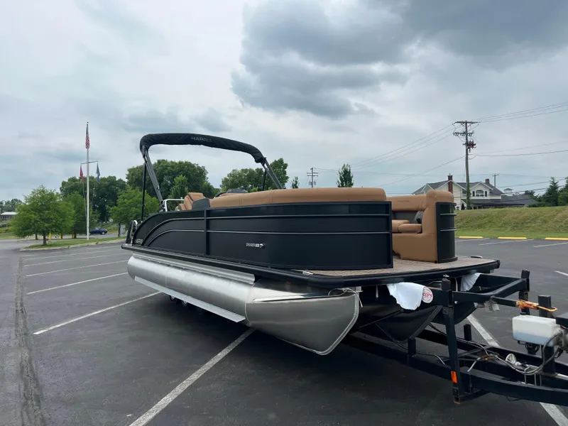 Slide: The Image of 2026 Harris Cruiser 230 pontoon boat on trailer in parking lot under cloudy sky. - 3