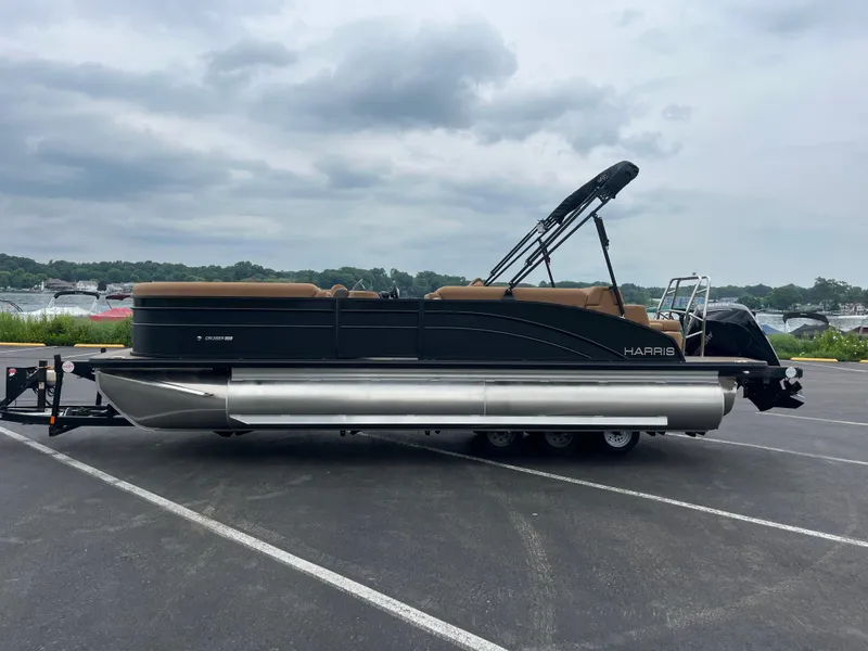 Slide: The Image of 2026 Harris Cruiser 230 pontoon boat parked on a trailer in a lot. - 9