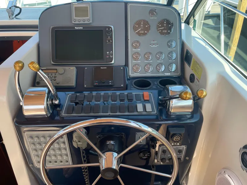 Slide: The Image of 1998 Tiara Yachts 3500 Open helm with navigation controls and steering wheel. - 11