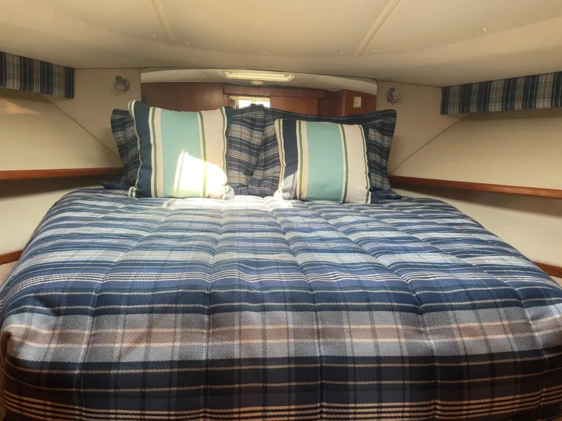 Slide: The Image of Cozy cabin interior of 1998 Tiara Yachts 3500 Open with plaid bedding and pillows. - 15