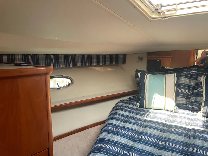 Slide: The Image of Cozy cabin interior of 1998 Tiara Yachts 3500 Open with plaid bedding and wooden cabinetry. - 17