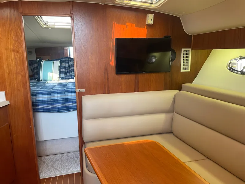 Slide: The Image of 1998 Tiara Yachts 3500 Open interior with cozy seating, TV, and bedroom view. - 28
