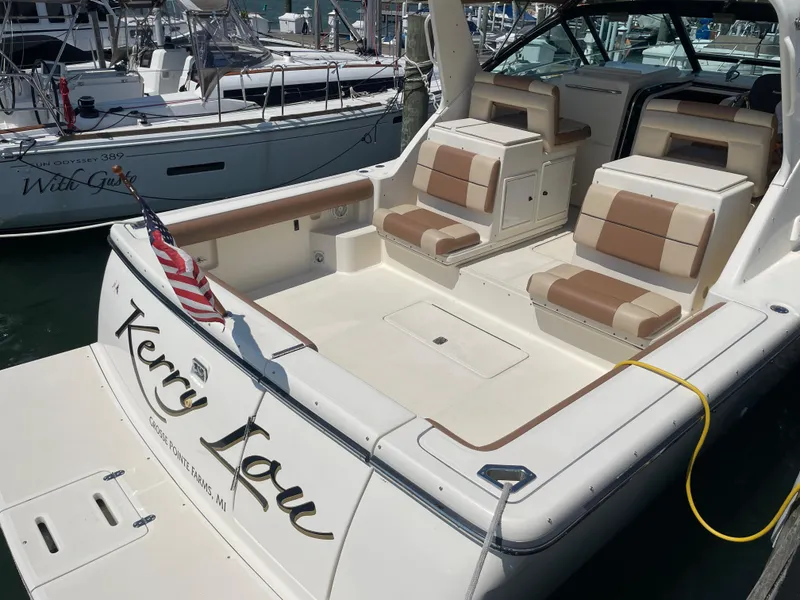 Slide: The Image of 1998 Tiara Yachts 3500 Open with seating and American flag at marina. - 4